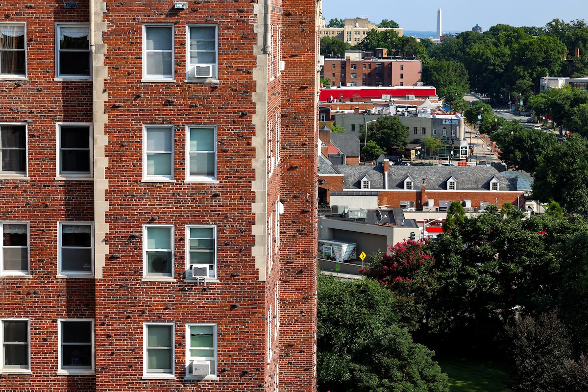 Air conditioner units in windows of an apartment building in Washington, DC