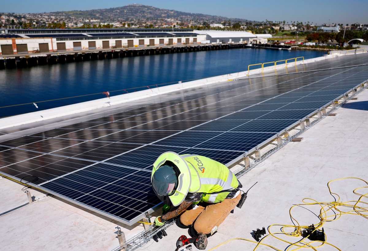 A worker installs solar panels on a 4-acre solar rooftop at AltaSea's research and development facility at the Port of Los Angeles in Los Angeles, California