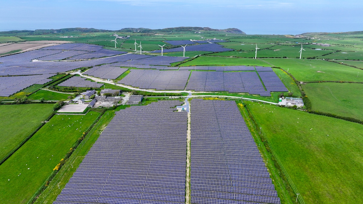 Aerial view of wind turbines next to the Lightsource bp solar farm near the Anglesey village of Rhosgoch in Wales